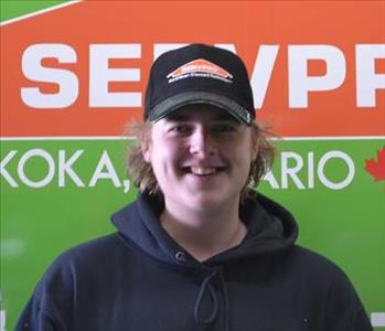Man with blonde hair wearing a Servpro hat smiling